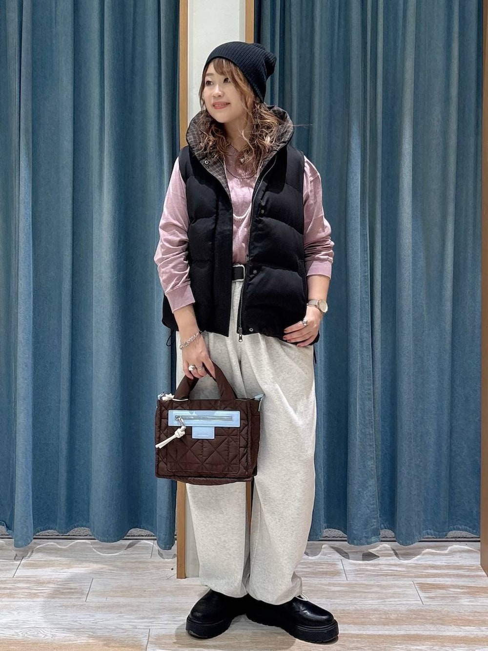 ベージュ系のスウェットパンツ、ブラック系のその他アウター、ブラウン系のショルダーバッグを着用したレディースの秋コーディネートの4枚目の写真