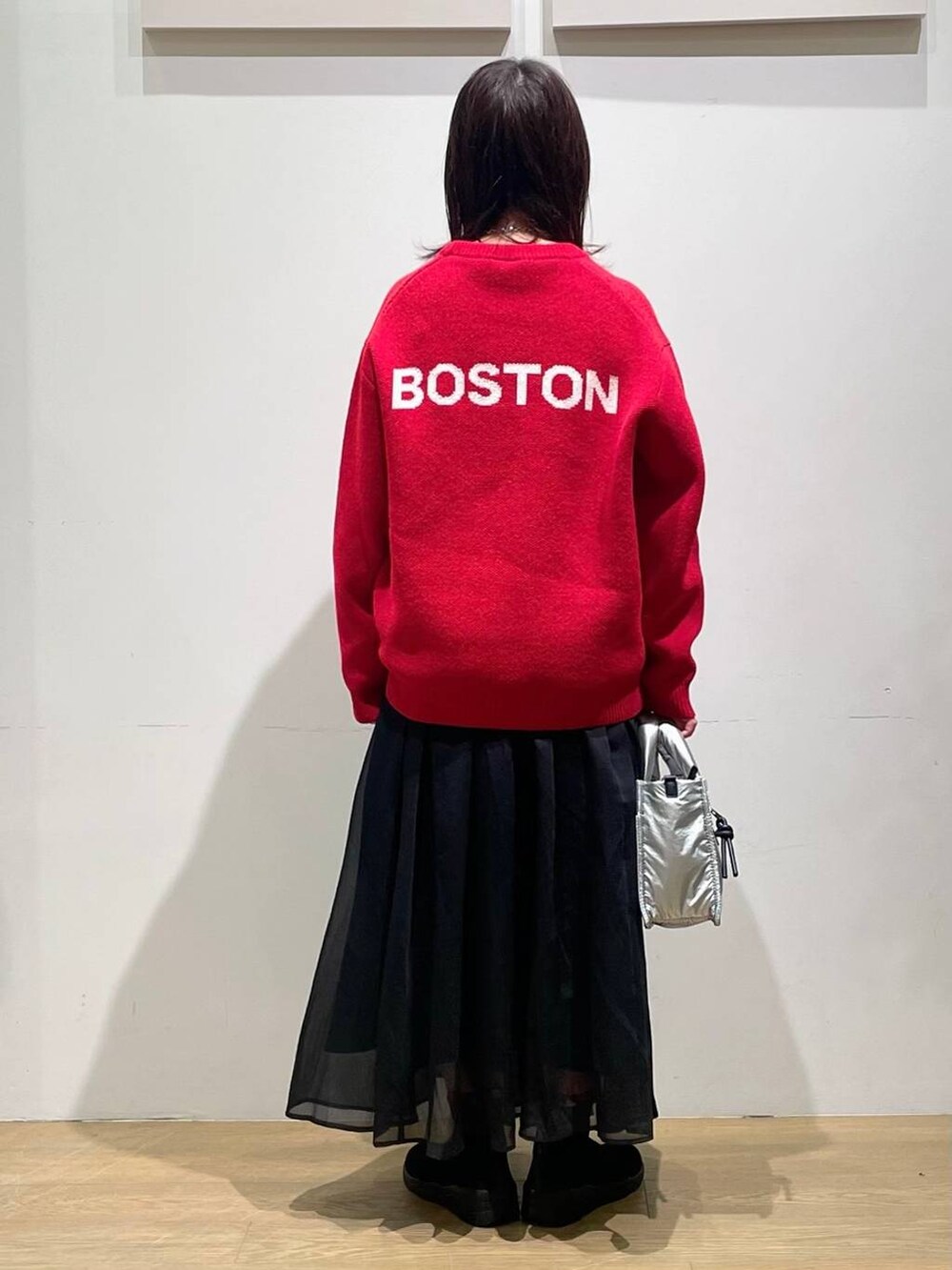 シルバー系のショルダーバッグ、ブラック系のブーツ、レッド系のニット/セーターを着用したレディースの秋コーディネートの3枚目の写真