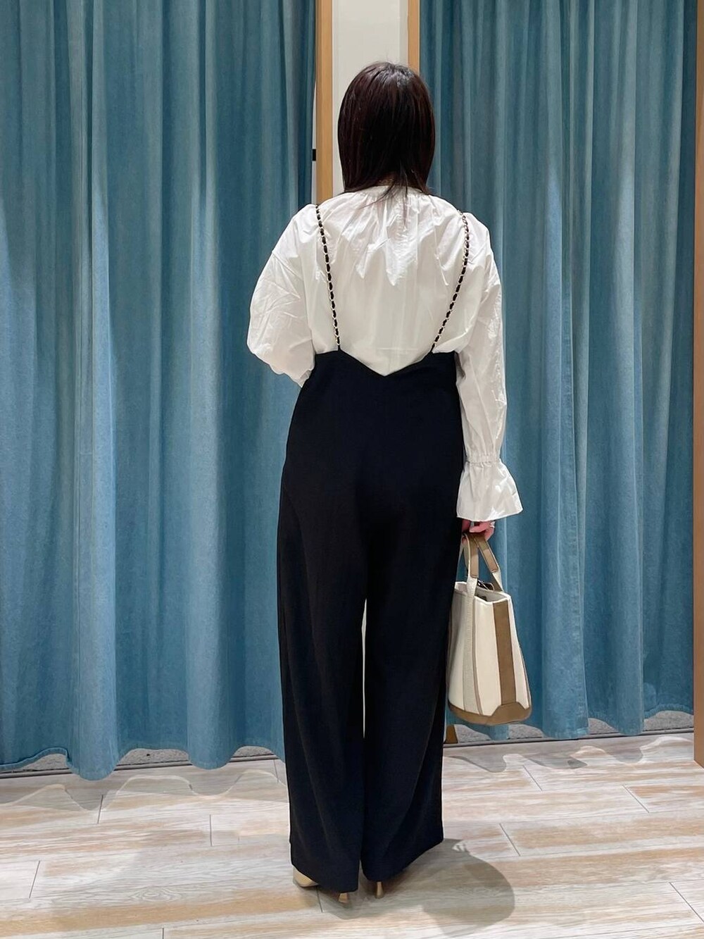 ゴールド系のパンプス、ホワイト系のトートバッグ、ホワイト系のシャツ/ブラウスを着用したレディースの冬コーディネートの3枚目の写真