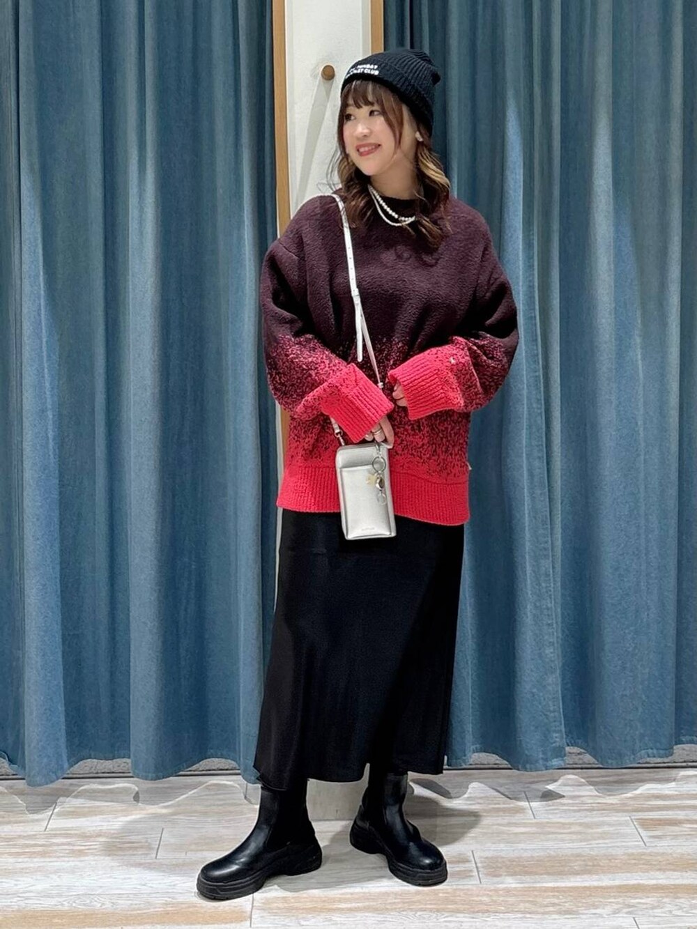 ブラック系のブーツ、ブラック系のスカート、ピンク系のニット/セーターを着用したレディースの秋コーディネートの4枚目の写真