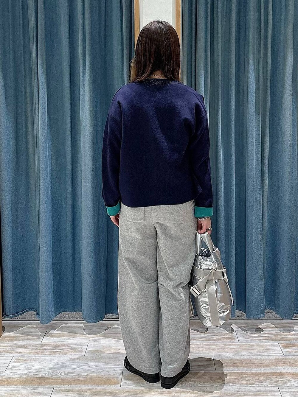 シルバー系のトートバッグ、ブラック系のローファー、ブルー系のカーディガン/ボレロを着用したレディースの冬コーディネートの3枚目の写真