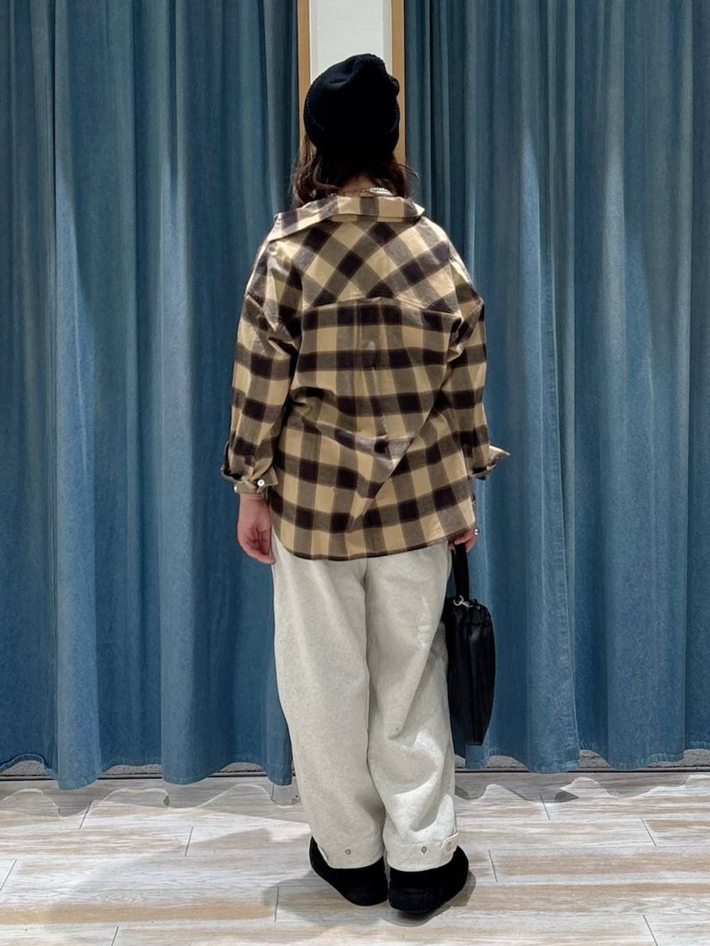 ブラック系のブーツ、ブラック系のハンドバッグ、ベージュ系のシャツ/ブラウスを着用したレディースの秋コーディネートの3枚目の写真