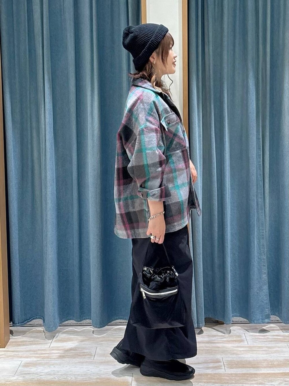 ブラック系のスカート、グレー系のその他アウター、ブラック系のブーツを着用したレディースの秋コーディネートの2枚目の写真