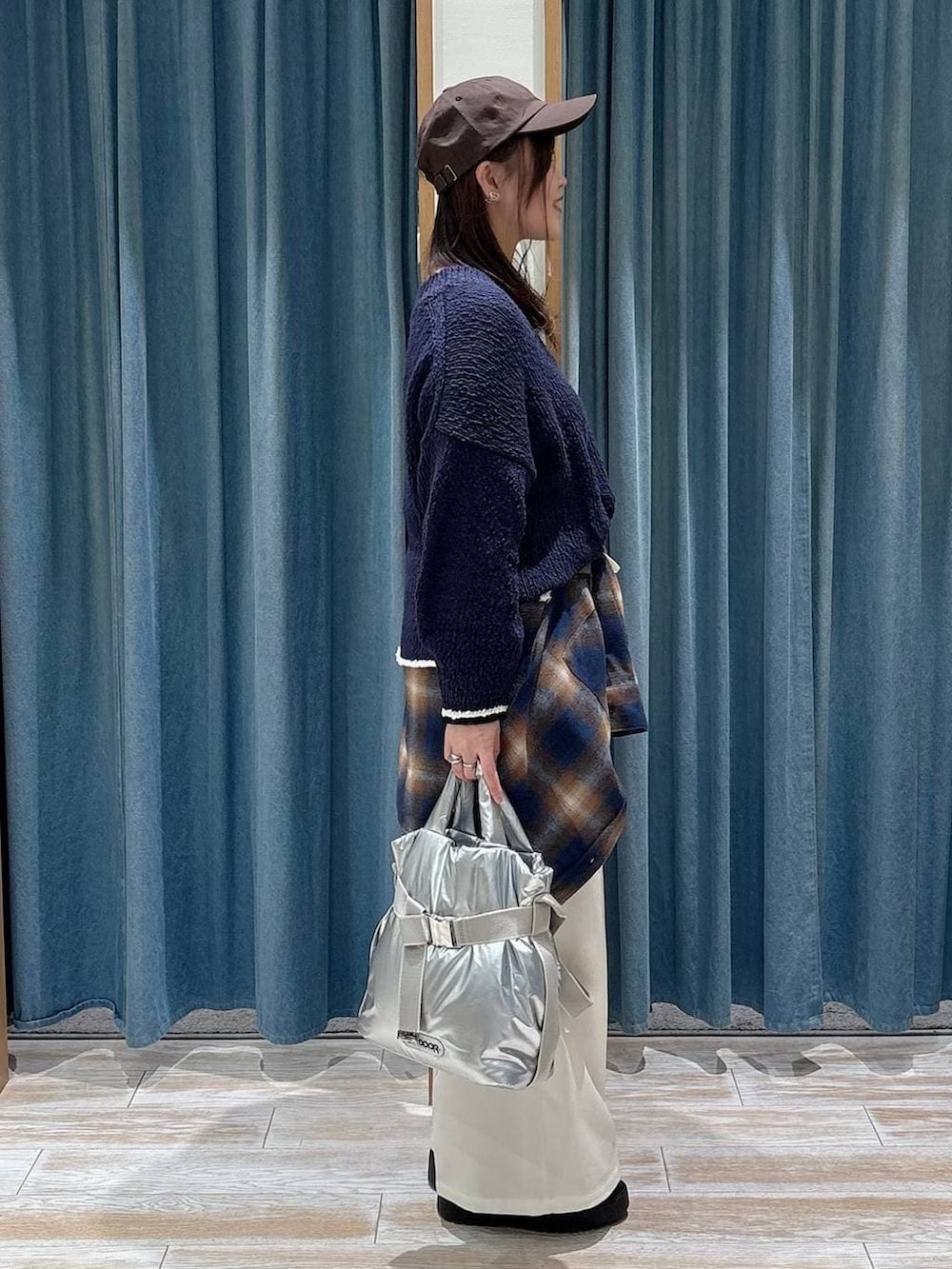 シルバー系のトートバッグ、ブラック系のブーツ、ブラック系のTシャツ/カットソーを着用したレディースの冬コーディネートの2枚目の写真