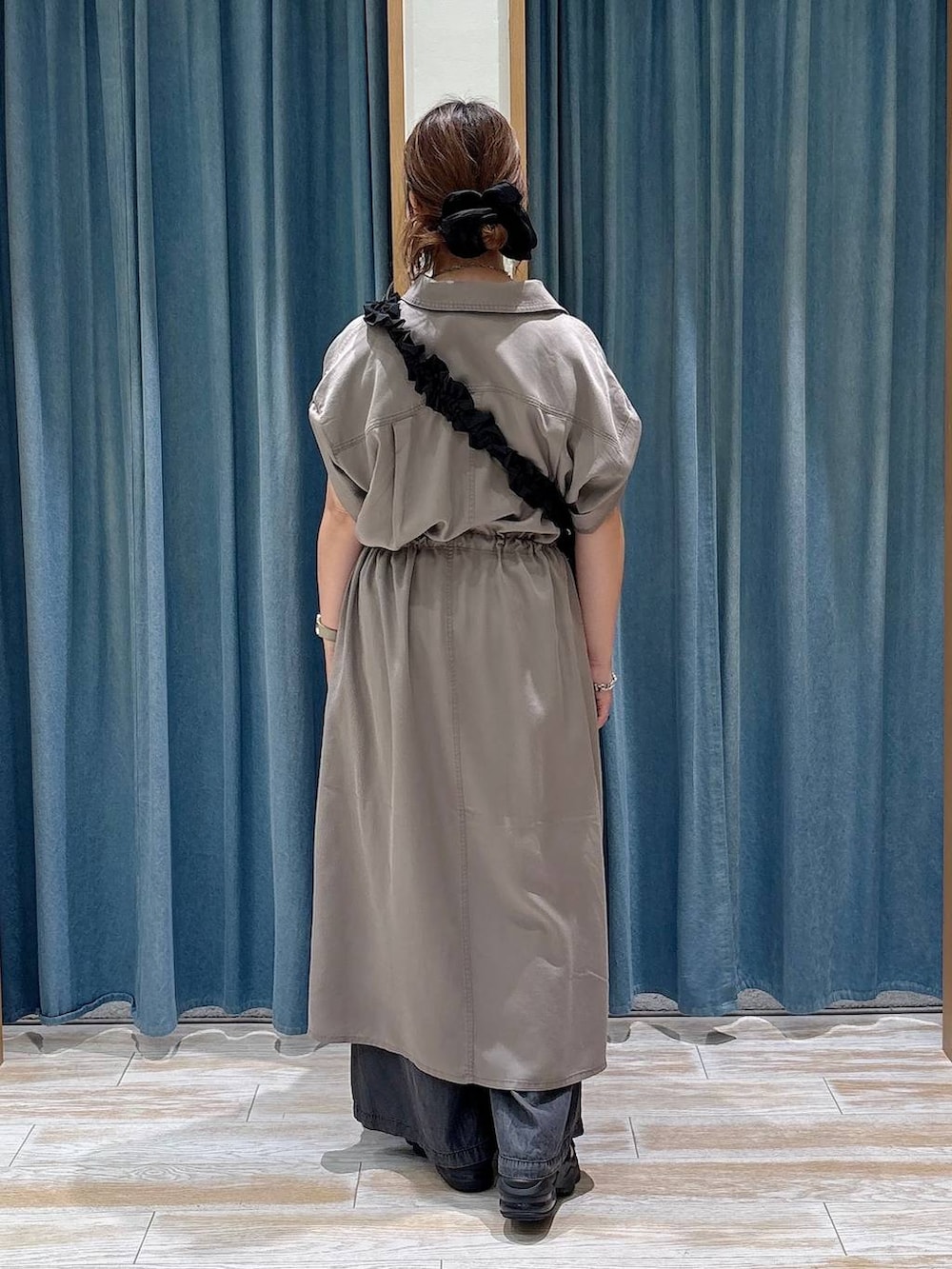 ブラック系のデニムパンツ、ブラック系のショルダーバッグ、ブラウン系のワンピースを着用したレディースの夏コーディネートの3枚目の写真