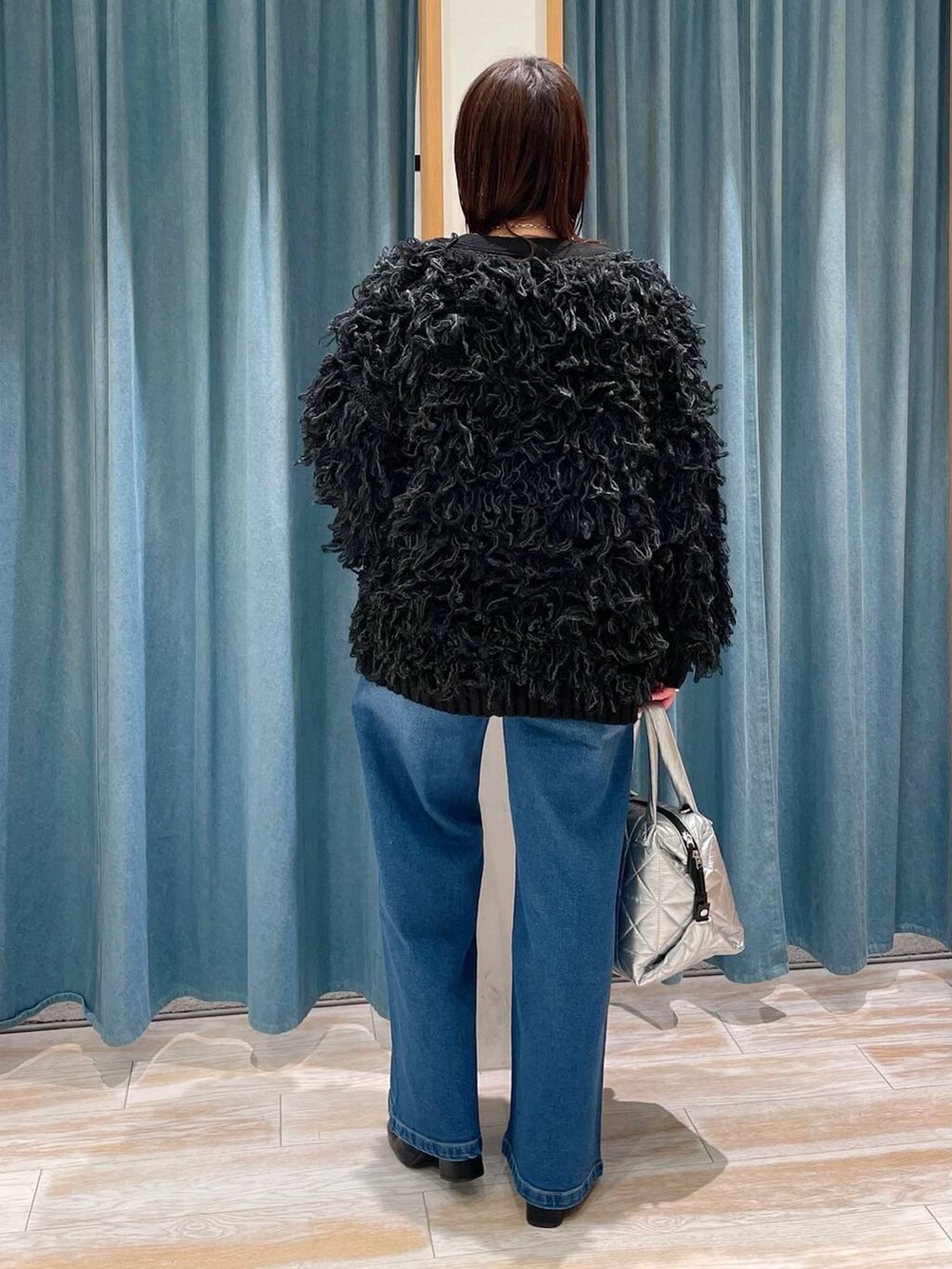 ブラック系のブーツ、レッド系のTシャツ/カットソー、シルバー系のトートバッグを着用したレディースの冬コーディネートの3枚目の写真