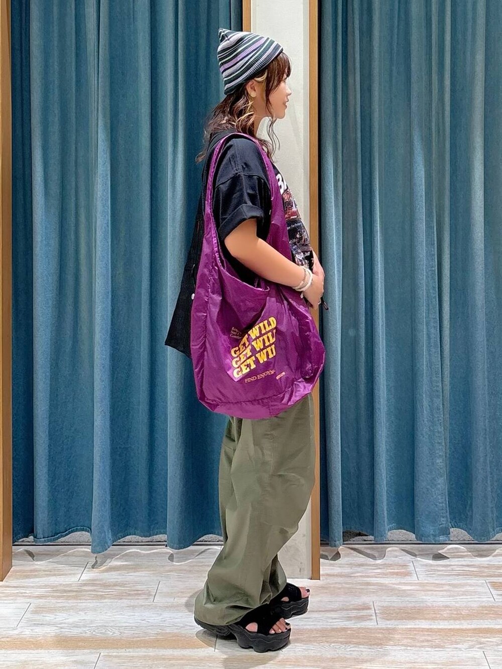 パープル系のエコバッグ/サブバッグ、ブラック系のTシャツ/カットソー、グリーン系のその他パンツを着用したレディースの夏コーディネートの2枚目の写真