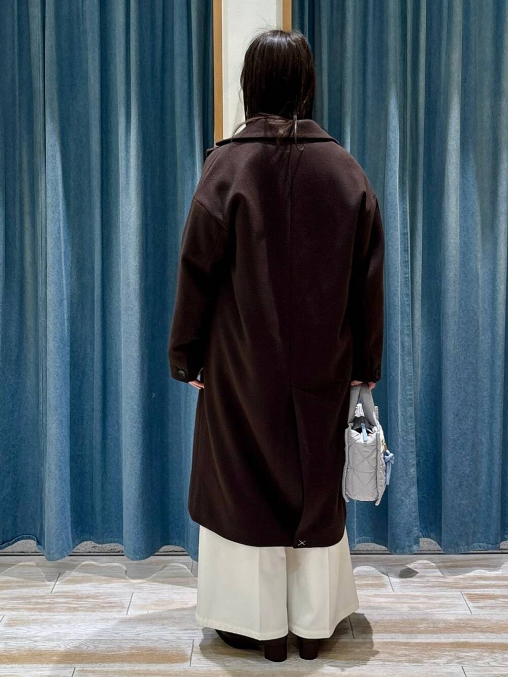 グレー系のショルダーバッグ、ベージュ系のその他パンツ、ブラウン系のチェスターコートを着用したレディースの冬コーディネートの3枚目の写真