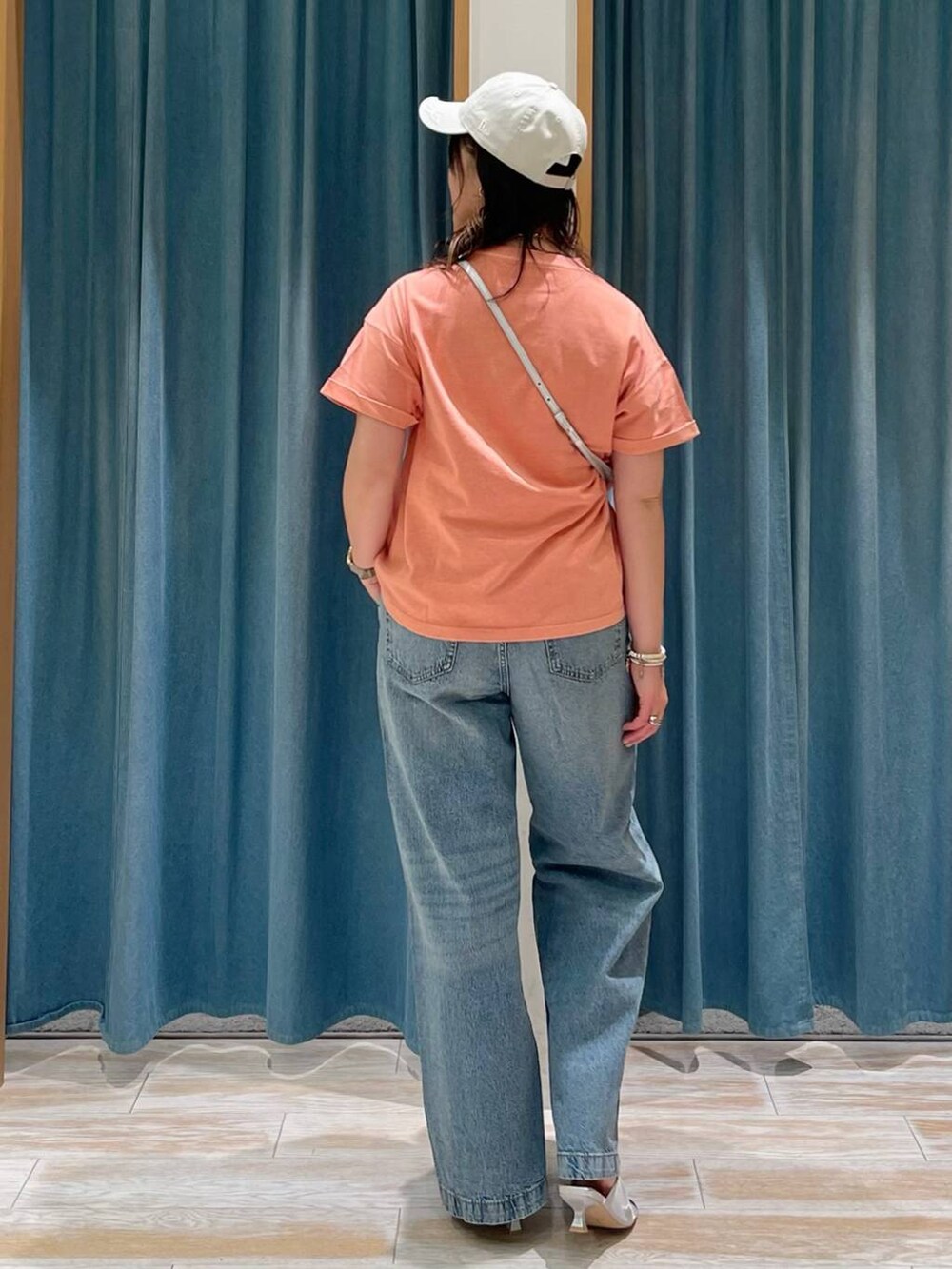 ブラウン系のTシャツ/カットソー、シルバー系のサンダル、ブルー系のデニムパンツを着用したレディースの春コーディネートの3枚目の写真