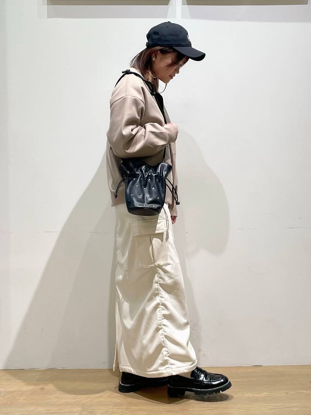 ブラック系のローファー、ブラウン系のブルゾン、ブラック系のショルダーバッグを着用したレディースの秋コーディネートの2枚目の写真