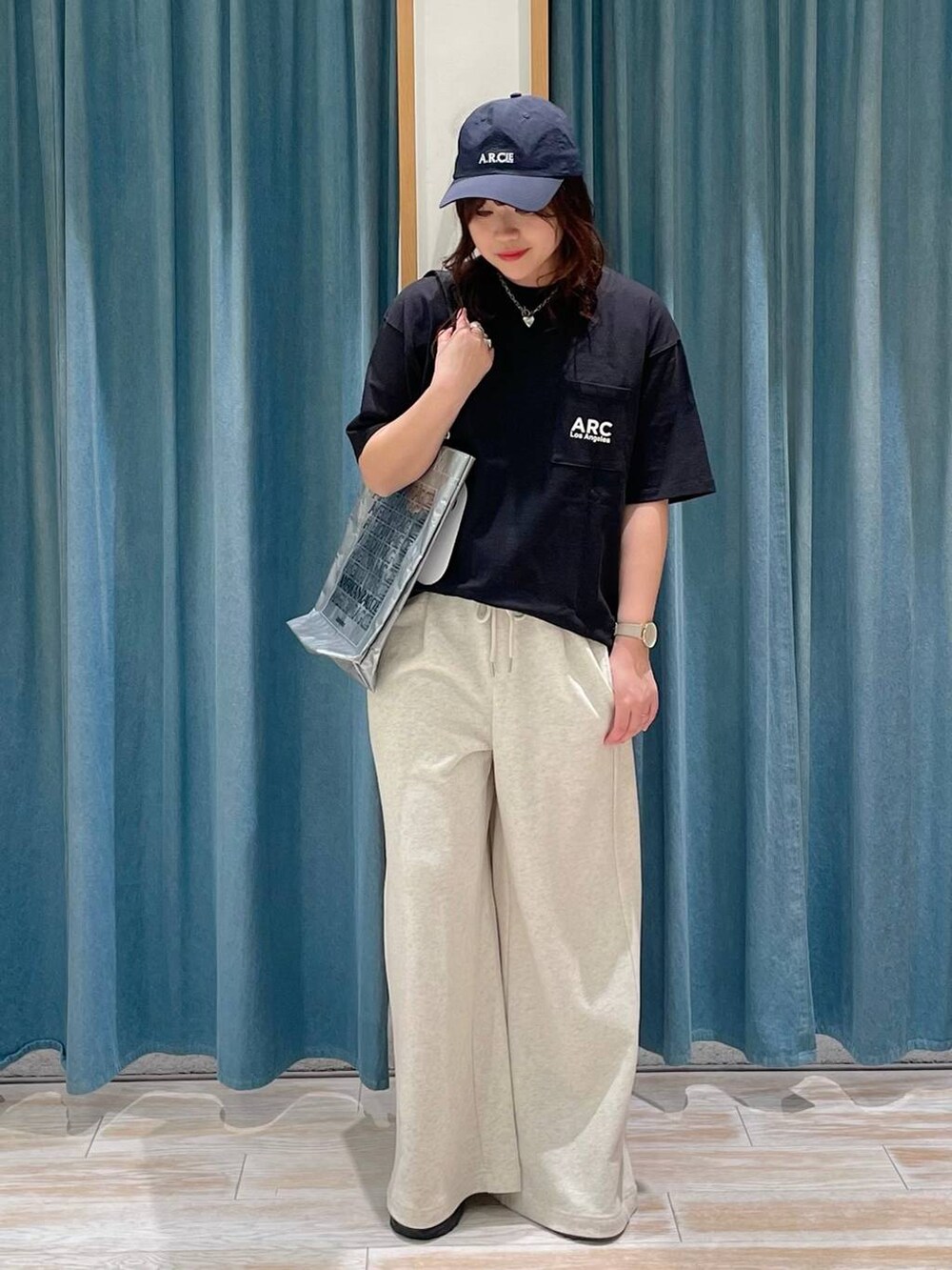 ベージュ系のスウェットパンツ、シルバー系のトートバッグ、ブラック系のTシャツ/カットソーを着用したレディースの春コーディネートの2枚目の写真