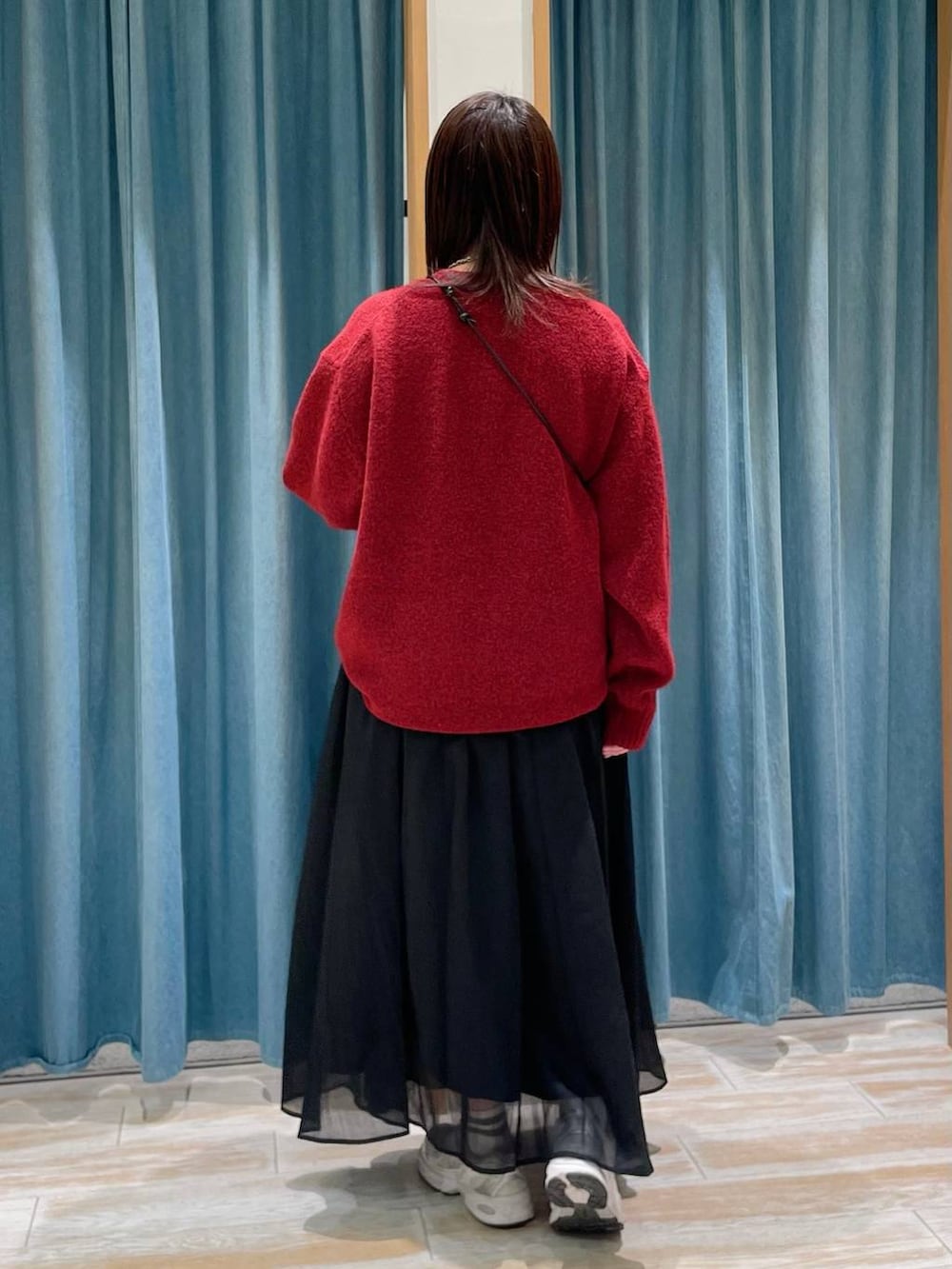 グレー系のショルダーバッグ、レッド系のニット/セーター、ブラック系のスカートを着用したレディースの冬コーディネートの2枚目の写真