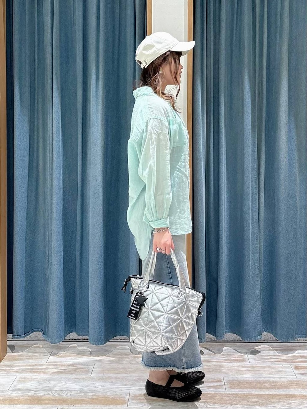 グリーン系のシャツ/ブラウス、ブルー系のデニムスカート、ブラック系のパンプスを着用したレディースの春コーディネートの2枚目の写真