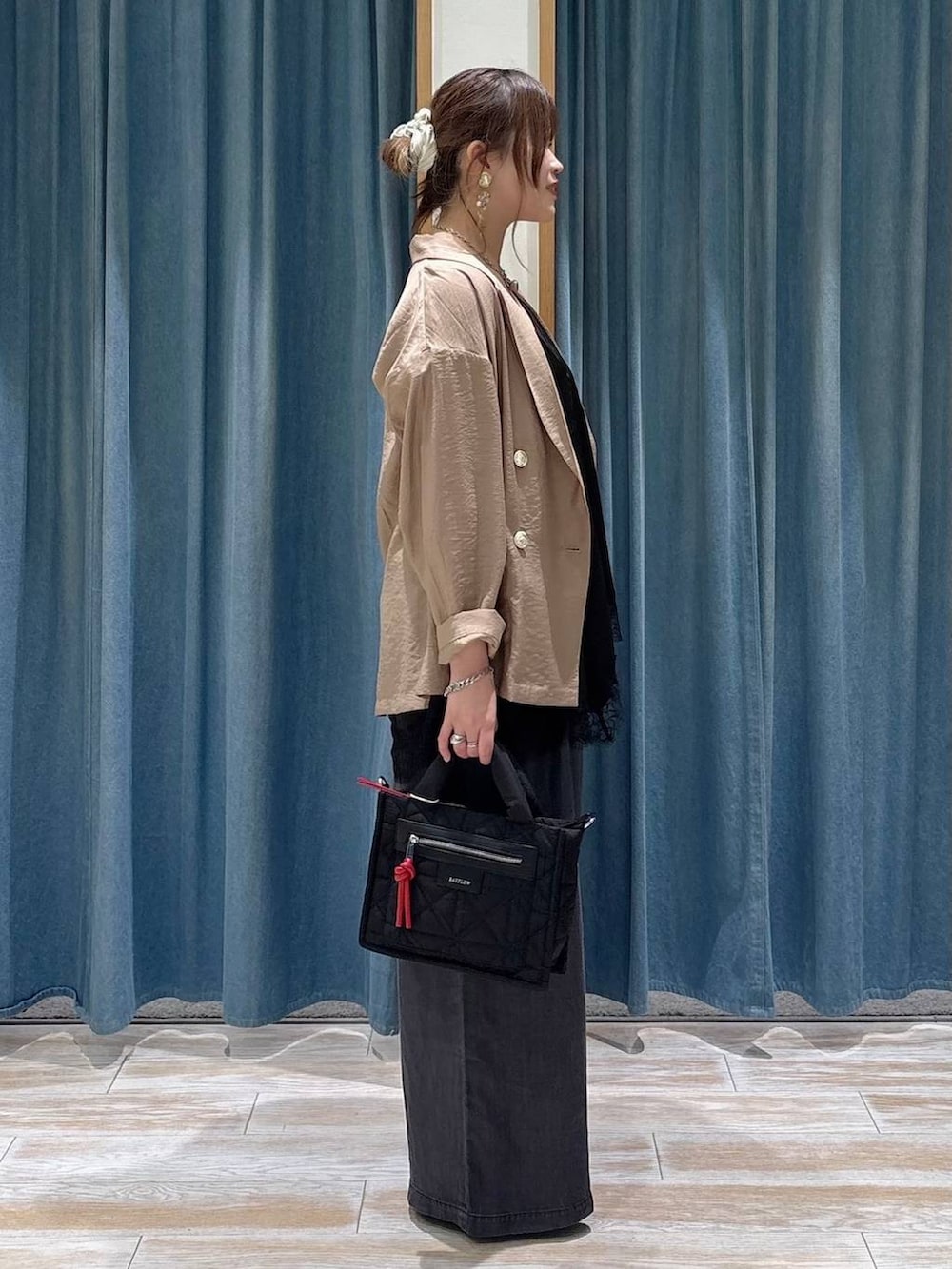 ブラック系のショルダーバッグ、ブラック系のデニムパンツ、ブラック系のキャミソールを着用したレディースの春コーディネートの2枚目の写真