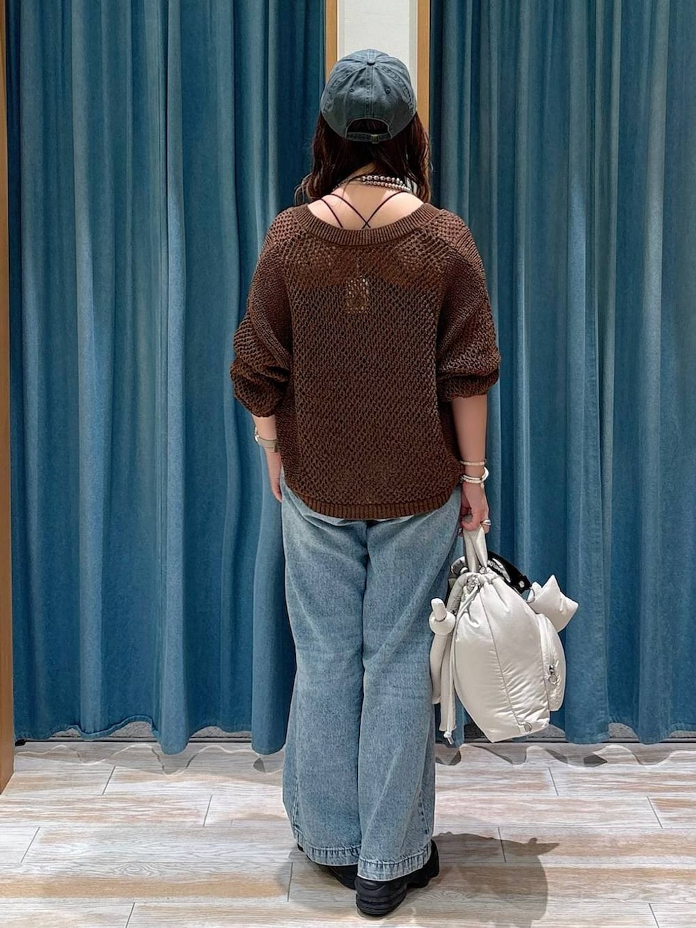 ブラック系のキャミソール、ブルー系のデニムパンツ、ホワイト系のトートバッグを着用したレディースの夏コーディネートの3枚目の写真