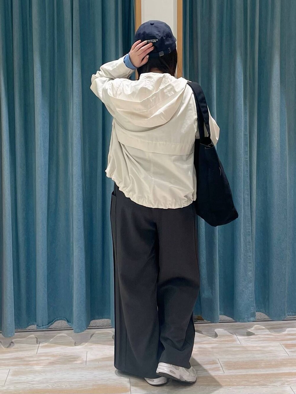 ホワイト系のマウンテンパーカー、グレー系のその他パンツ、ブルー系のTシャツ/カットソーを着用したレディースの春コーディネートの3枚目の写真