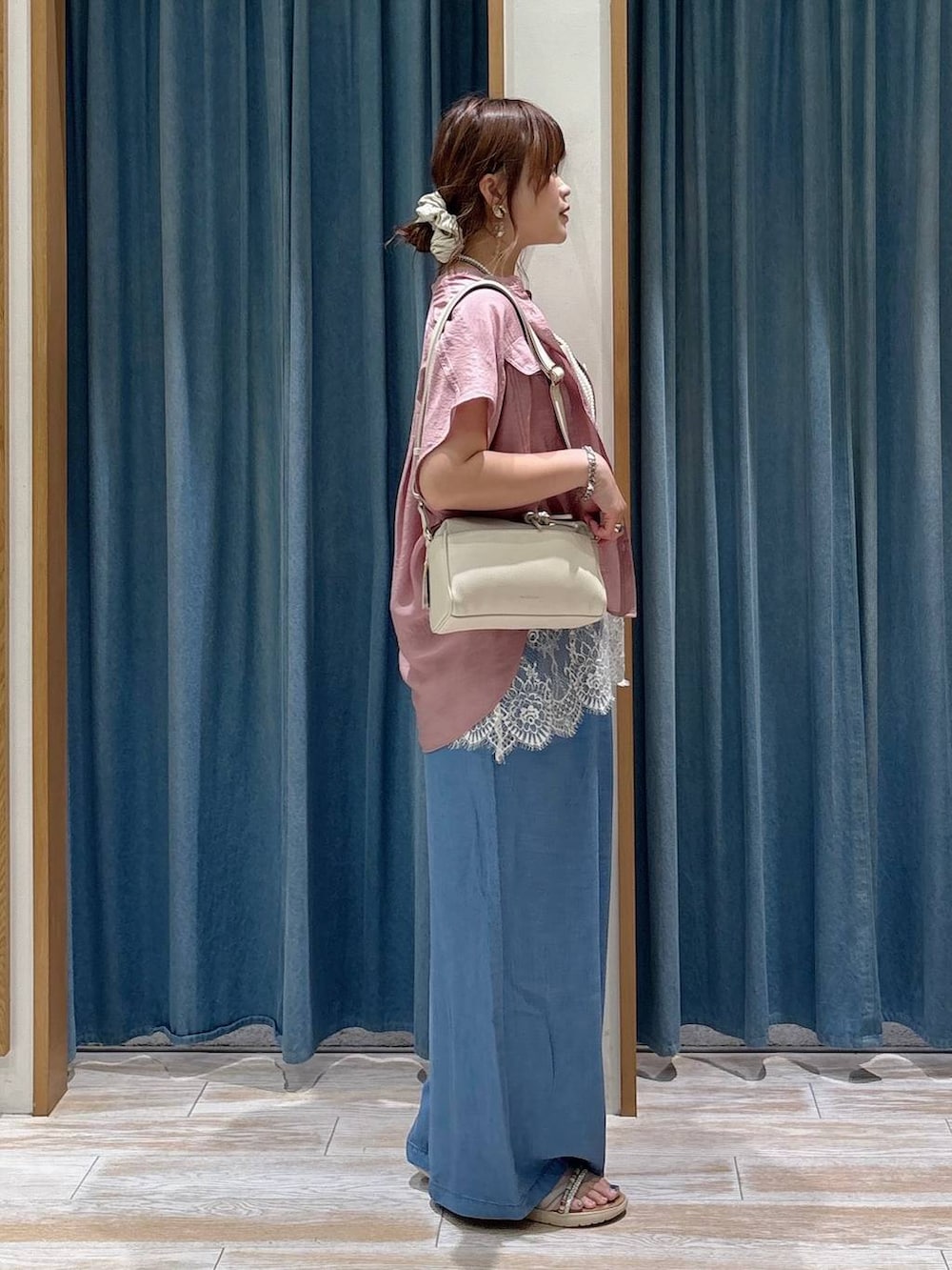 ブルー系のデニムパンツ、ピンク系のシャツ/ブラウス、シルバー系のサンダルを着用したレディースの夏コーディネートの2枚目の写真