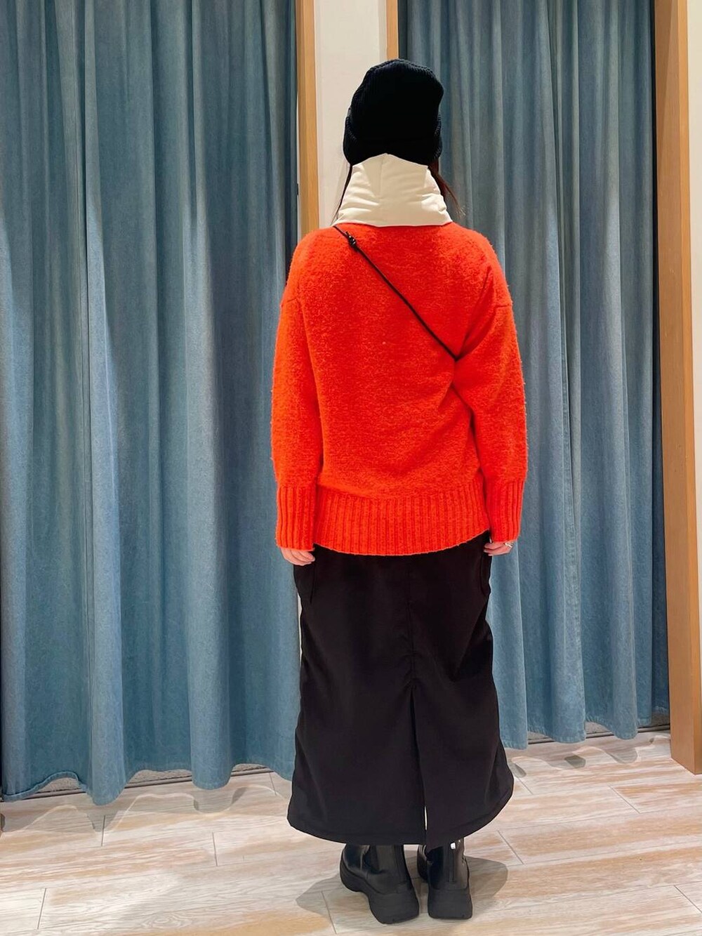 ブラック系のスカート、ブラック系のブーツ、ブラウン系のショルダーバッグを着用したレディースの冬コーディネートの2枚目の写真