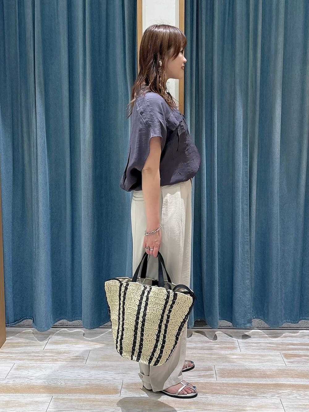 グレー系のシャツ/ブラウス、ベージュ系のトートバッグ、シルバー系のサンダルを着用したレディースの春コーディネートの2枚目の写真