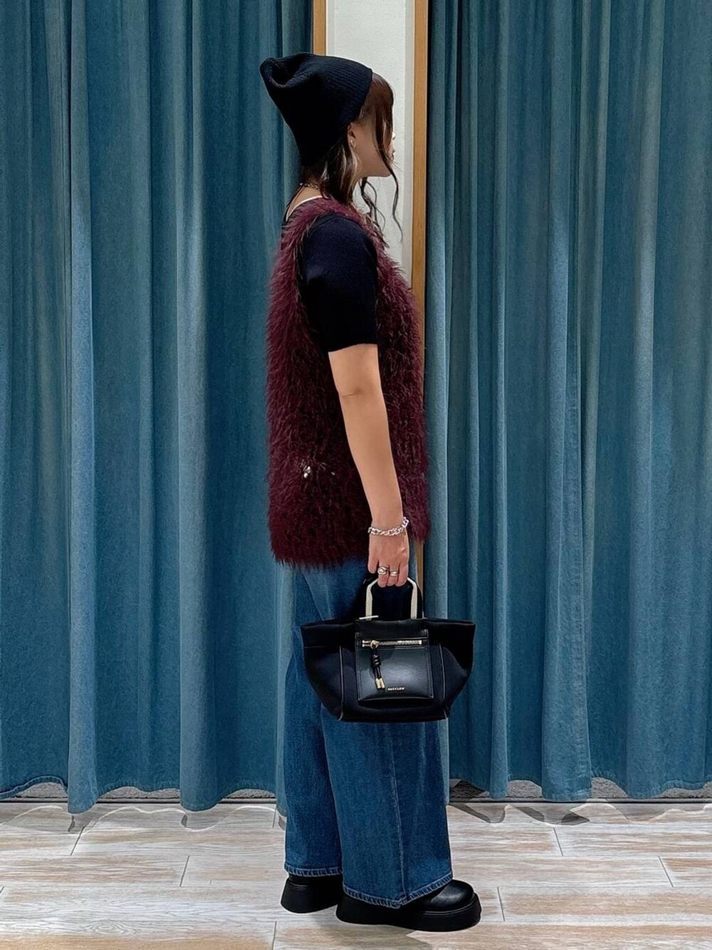 ブラック系のショルダーバッグ、ブラック系のサンダル、ブラック系のニット/セーターを着用したレディースの秋コーディネートの2枚目の写真