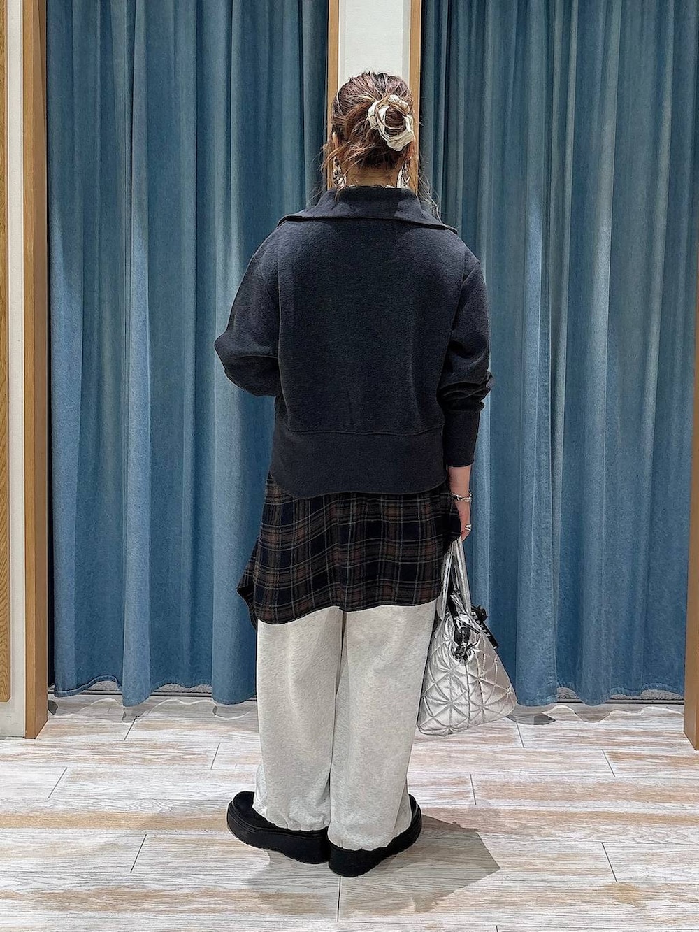 ベージュ系のスウェットパンツ、ブラック系のブーツ、ブラック系のシャツ/ブラウスを着用したレディースの秋コーディネートの3枚目の写真