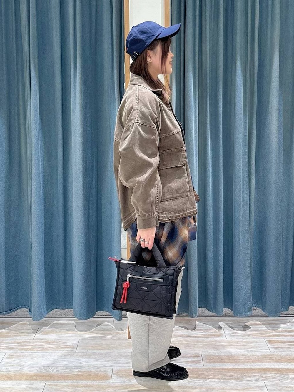 ブラック系のショルダーバッグ、ブラック系のTシャツ/カットソー、ブルー系のシャツ/ブラウスを着用したレディースの冬コーディネートの2枚目の写真