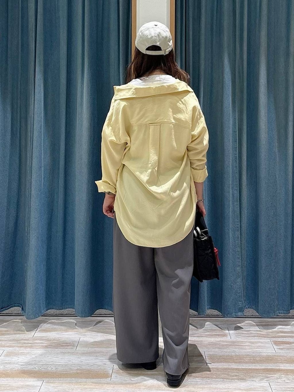 ブラック系のショルダーバッグ、イエロー系のシャツ/ブラウス、ホワイト系のTシャツ/カットソーを着用したレディースの春コーディネートの3枚目の写真