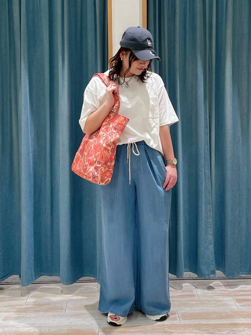 ブルー系のその他パンツ、ホワイト系のTシャツ/カットソー、レッド系のトートバッグを着用したレディースの春コーディネートの2枚目の写真