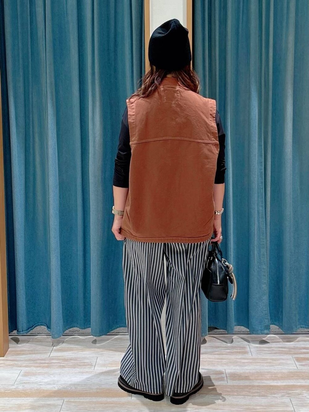 ブラック系のTシャツ/カットソー、ブラック系のボストンバッグ、ブラック系のローファーを着用したレディースの夏コーディネートの3枚目の写真