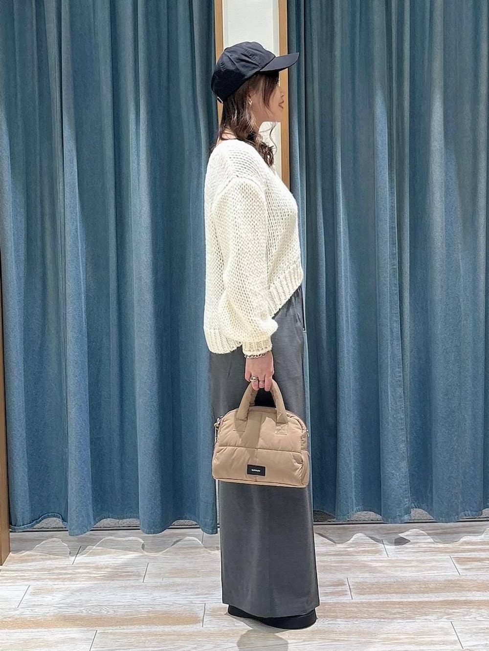 グレー系のその他パンツ、ベージュ系のボストンバッグ、ホワイト系のニット/セーターを着用したレディースの冬コーディネートの2枚目の写真