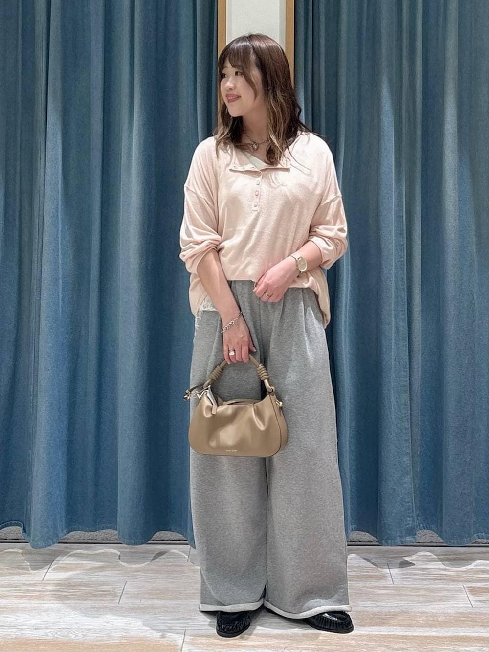 ベージュ系のハンドバッグ、ブラック系のローファー、ピンク系のニット/セーターを着用したレディースの春コーディネートの2枚目の写真