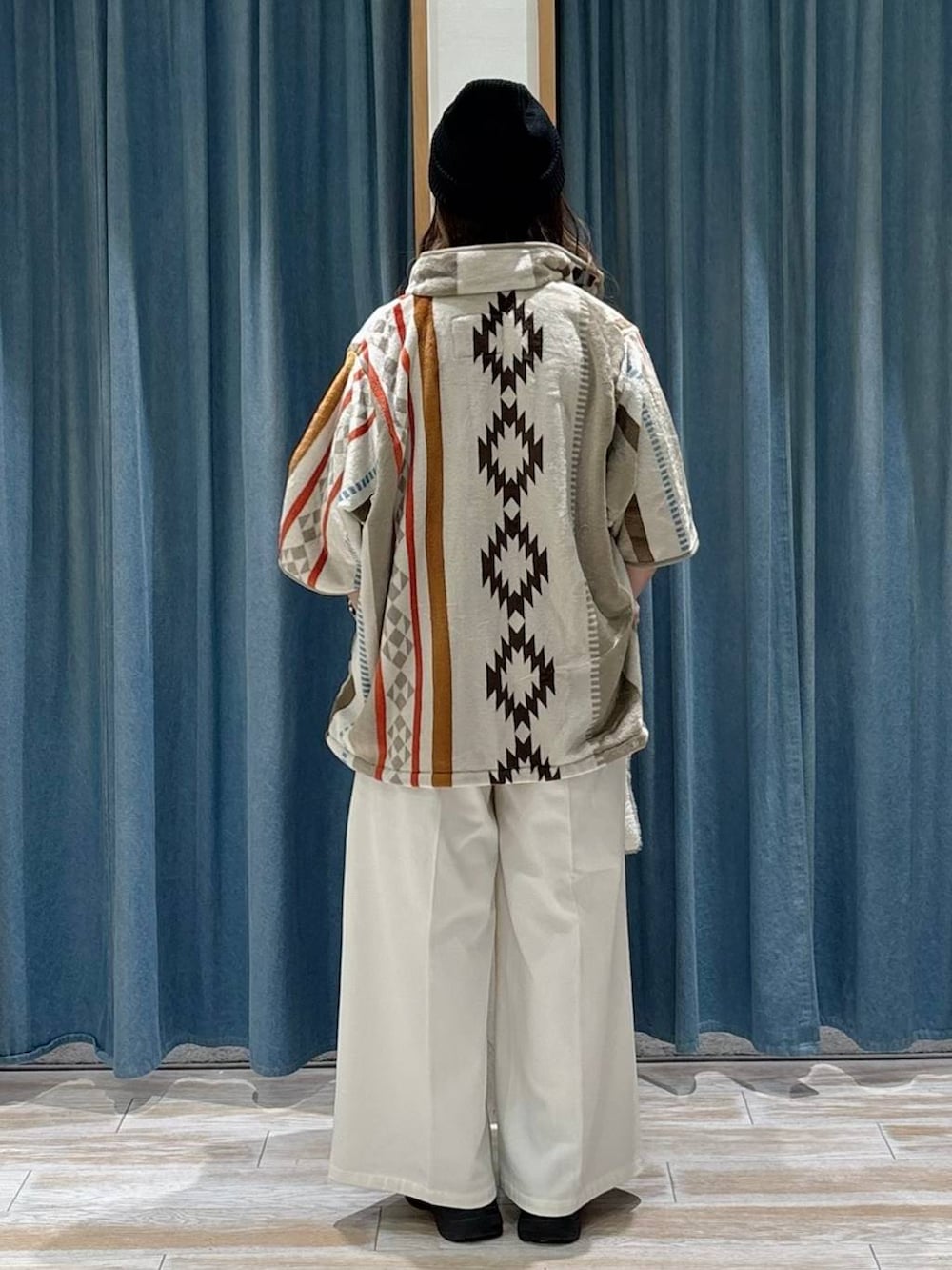 ベージュ系のその他パンツ、ブラック系のブーツ、グレー系のクッション/クッションカバーを着用したレディースの秋コーディネートの3枚目の写真