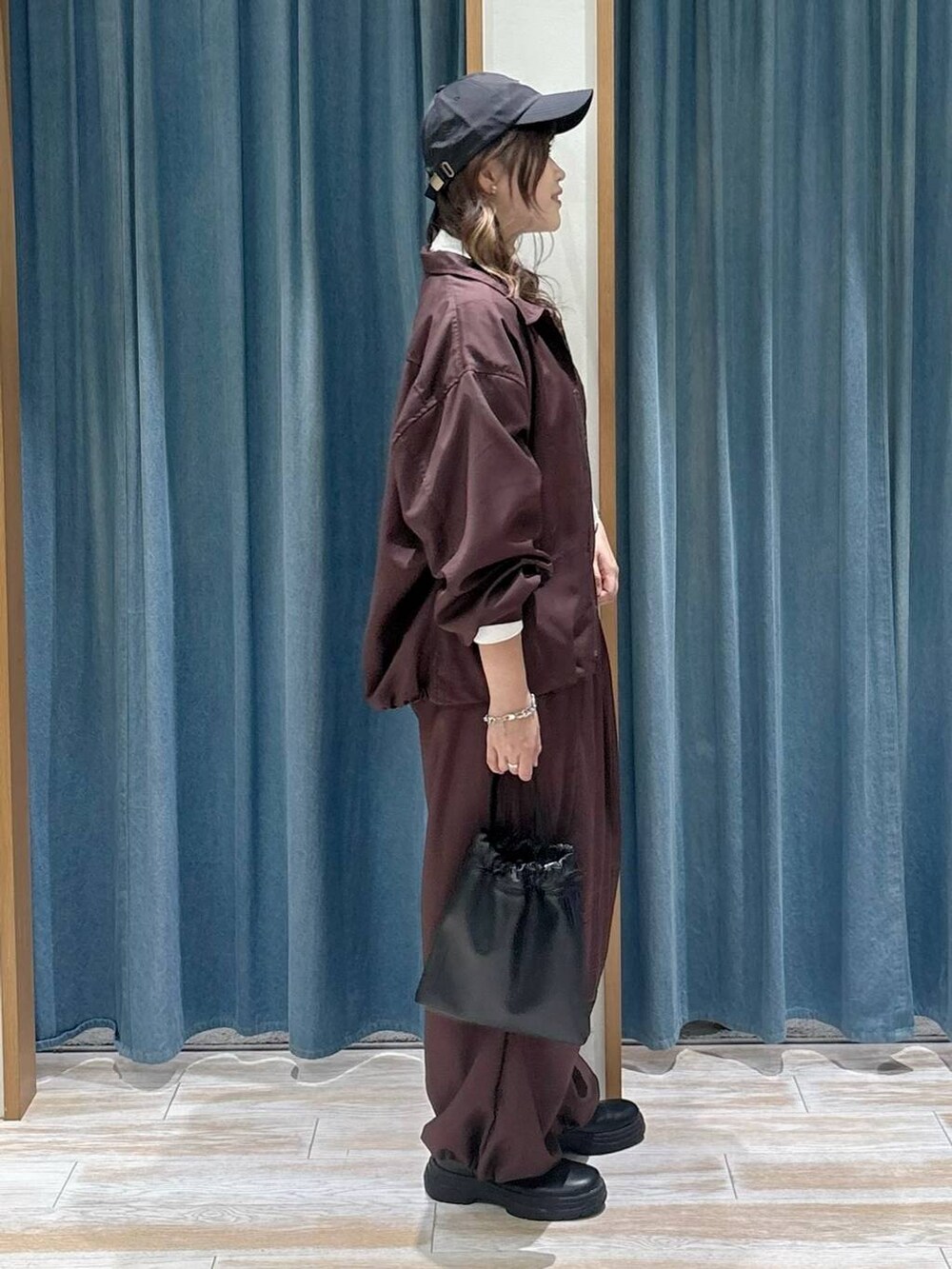 ブラック系のブーツ、ホワイト系のTシャツ/カットソー、ブラック系のハンドバッグを着用したレディースの秋コーディネートの2枚目の写真