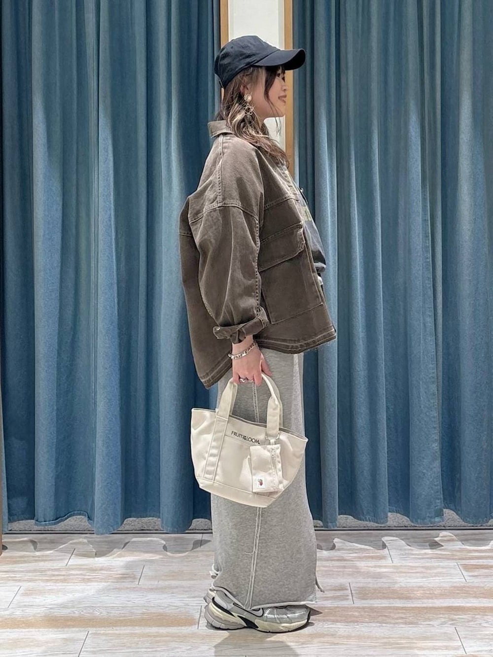 グレー系のTシャツ/カットソー、グレー系のスカート、ブラウン系のデニムジャケットを着用したレディースの春コーディネートの2枚目の写真