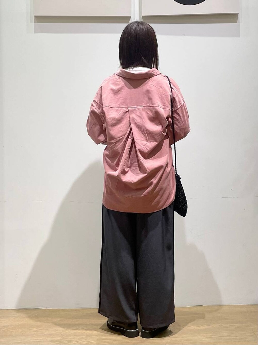 ピンク系のシャツ/ブラウス、グレー系のその他パンツ、ホワイト系のTシャツ/カットソーを着用したレディースの秋コーディネートの2枚目の写真