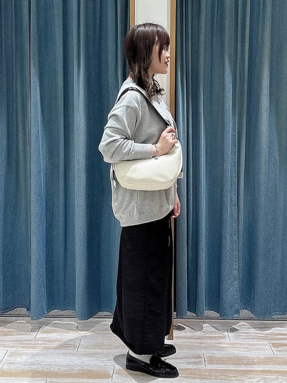 ブラック系のスカート、ブラック系のローファー、グレー系のスウェットを着用したレディースの冬コーディネートの2枚目の写真