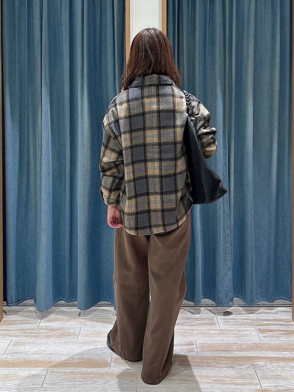 ブラウン系のスウェットパンツ、ブラック系のブーツ、イエロー系のシャツ/ブラウスを着用したレディースの秋コーディネートの3枚目の写真