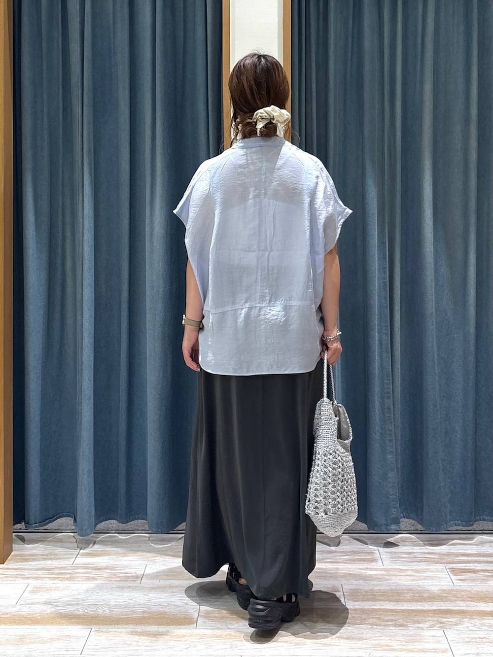 ブルー系のシャツ/ブラウス、グレー系のスカート、シルバー系のショルダーバッグを着用したレディースの夏コーディネートの3枚目の写真