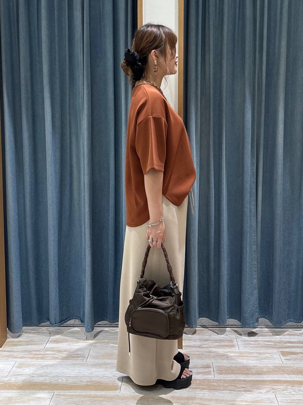 ブラウン系のショルダーバッグ、ベージュ系のその他パンツ、ブラウン系のTシャツ/カットソーを着用したレディースの夏コーディネートの2枚目の写真