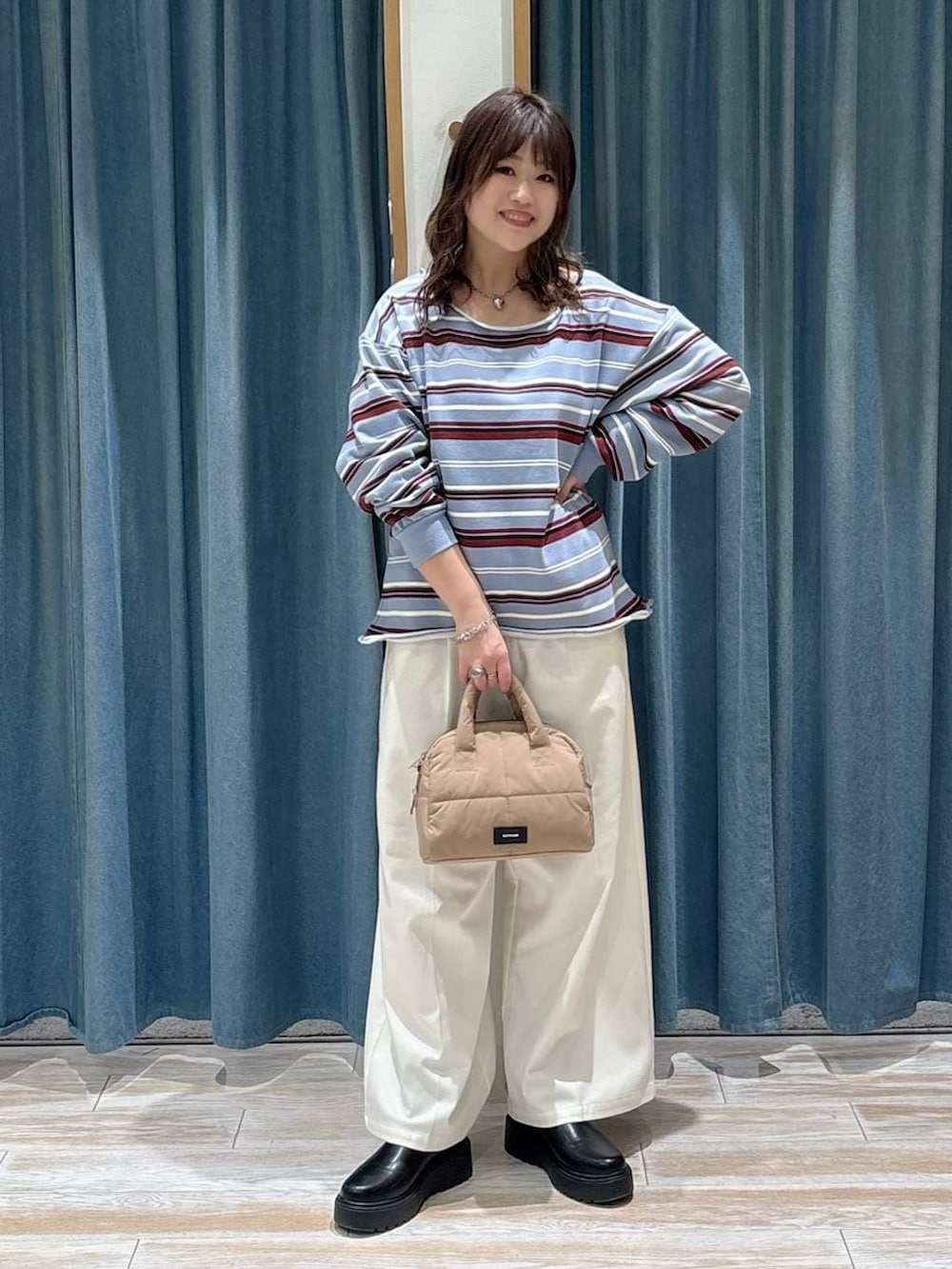 ベージュ系のその他パンツ、ブラック系のブーツ、ベージュ系のボストンバッグを着用したレディースの冬コーディネートの4枚目の写真