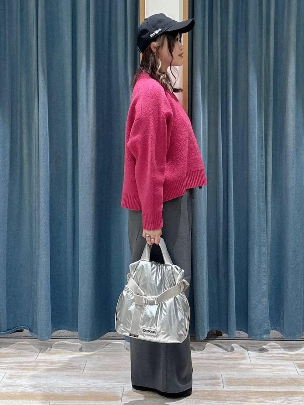 シルバー系のトートバッグ、グレー系のその他パンツ、ピンク系のニット/セーターを着用したレディースの冬コーディネートの2枚目の写真