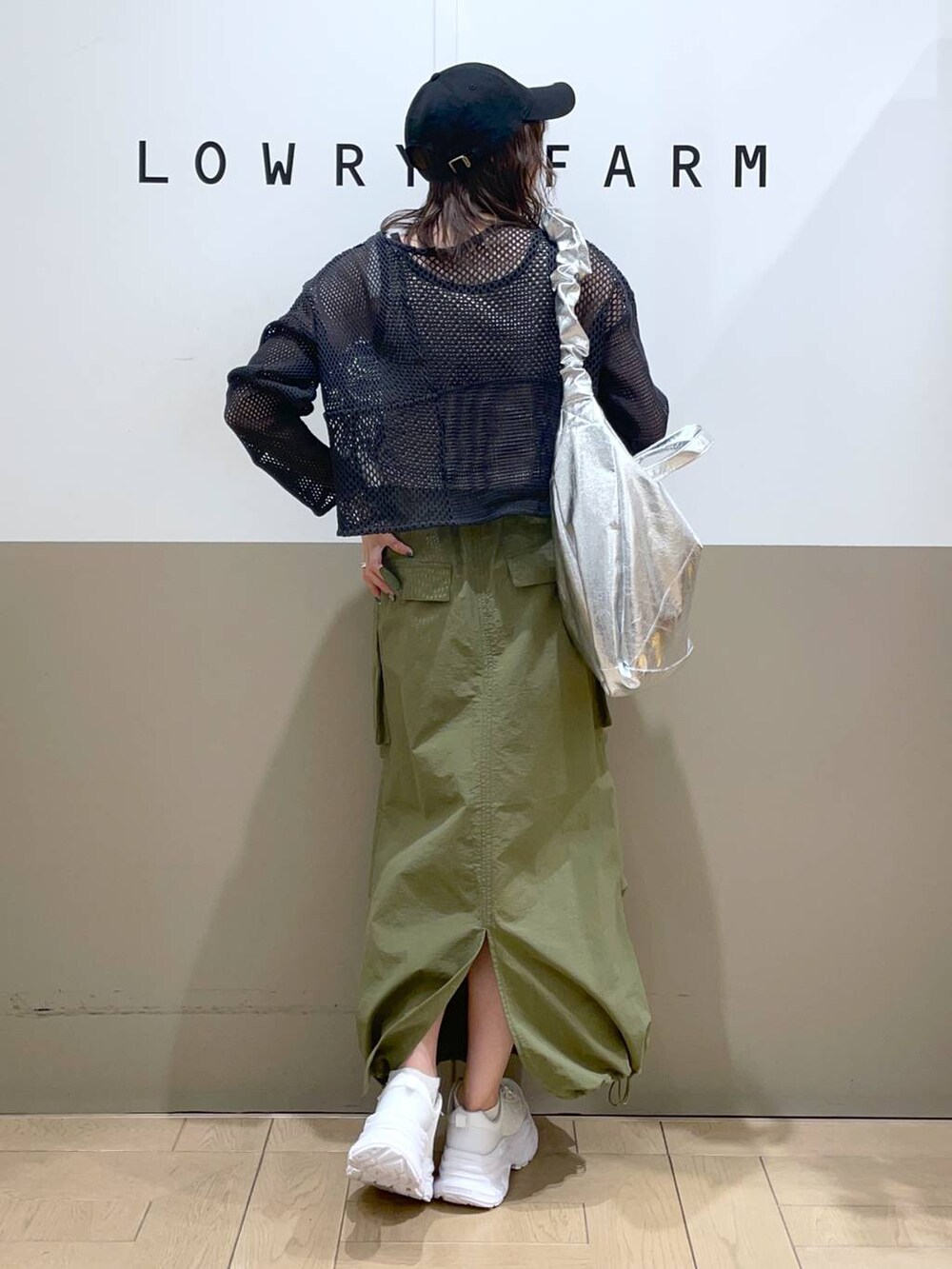 グレー系のトートバッグ、グレー系のニット/セーター、ブラック系のタンクトップを着用したレディースの春コーディネートの3枚目の写真