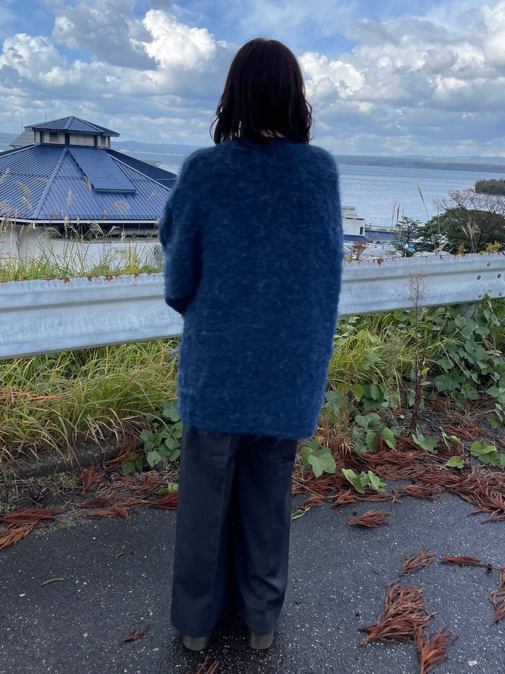 ブラック系のショルダーバッグ、グレー系のTシャツ/カットソー、グレー系のスラックスを着用したレディースの秋コーディネートの3枚目の写真