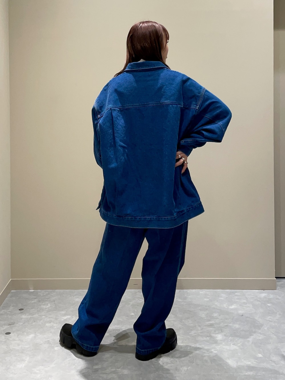 ブルー系のデニムジャケット、ブルー系のデニムパンツ、ホワイト系のショルダーバッグを着用したレディースの冬コーディネートの3枚目の写真