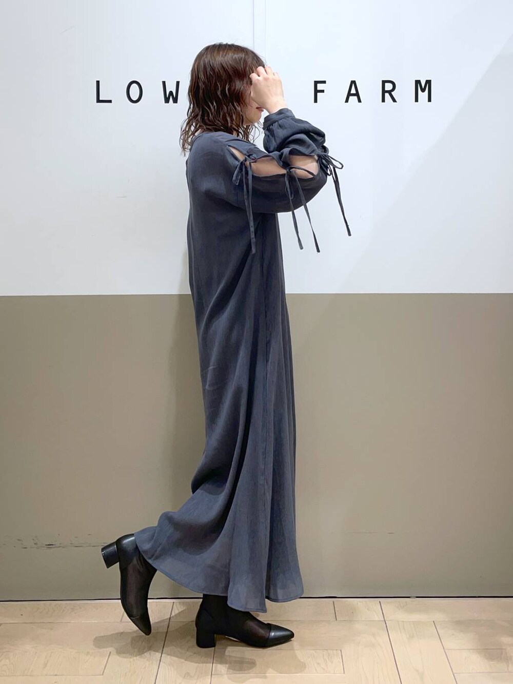 ブラック系のブーツ、グレー系のワンピースを着用したレディースの春コーディネートの2枚目の写真