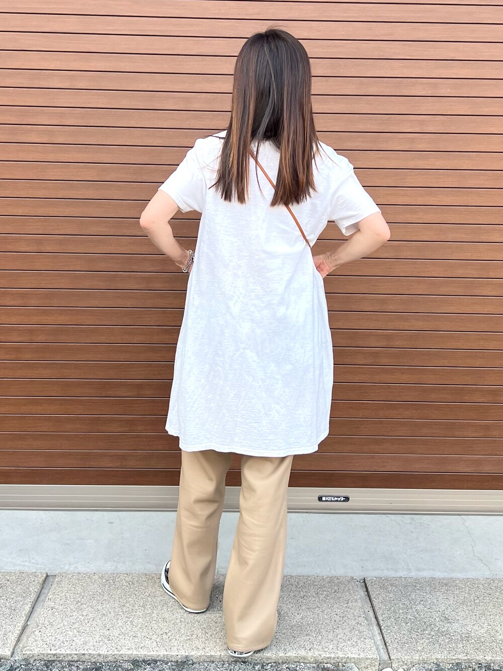 ベージュ系のデニムパンツ、ブラック系のスニーカー、ホワイト系のTシャツ/カットソーを着用したレディースの夏コーディネートの2枚目の写真