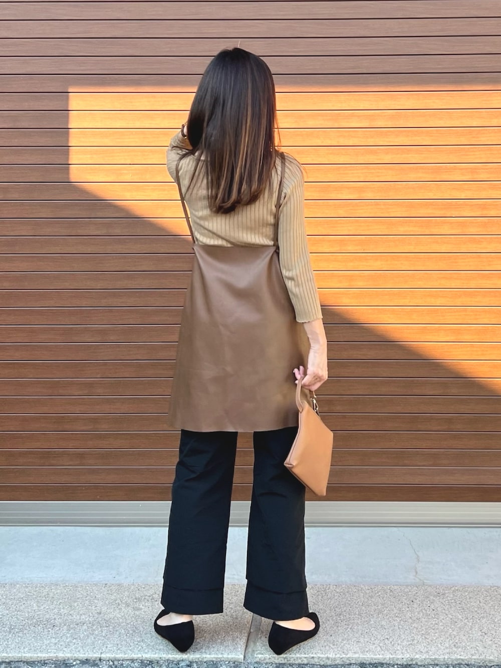 ブラウン系のベスト、ブラック系のその他パンツ、ベージュ系のニット/セーターを着用したレディースの秋コーディネートの3枚目の写真