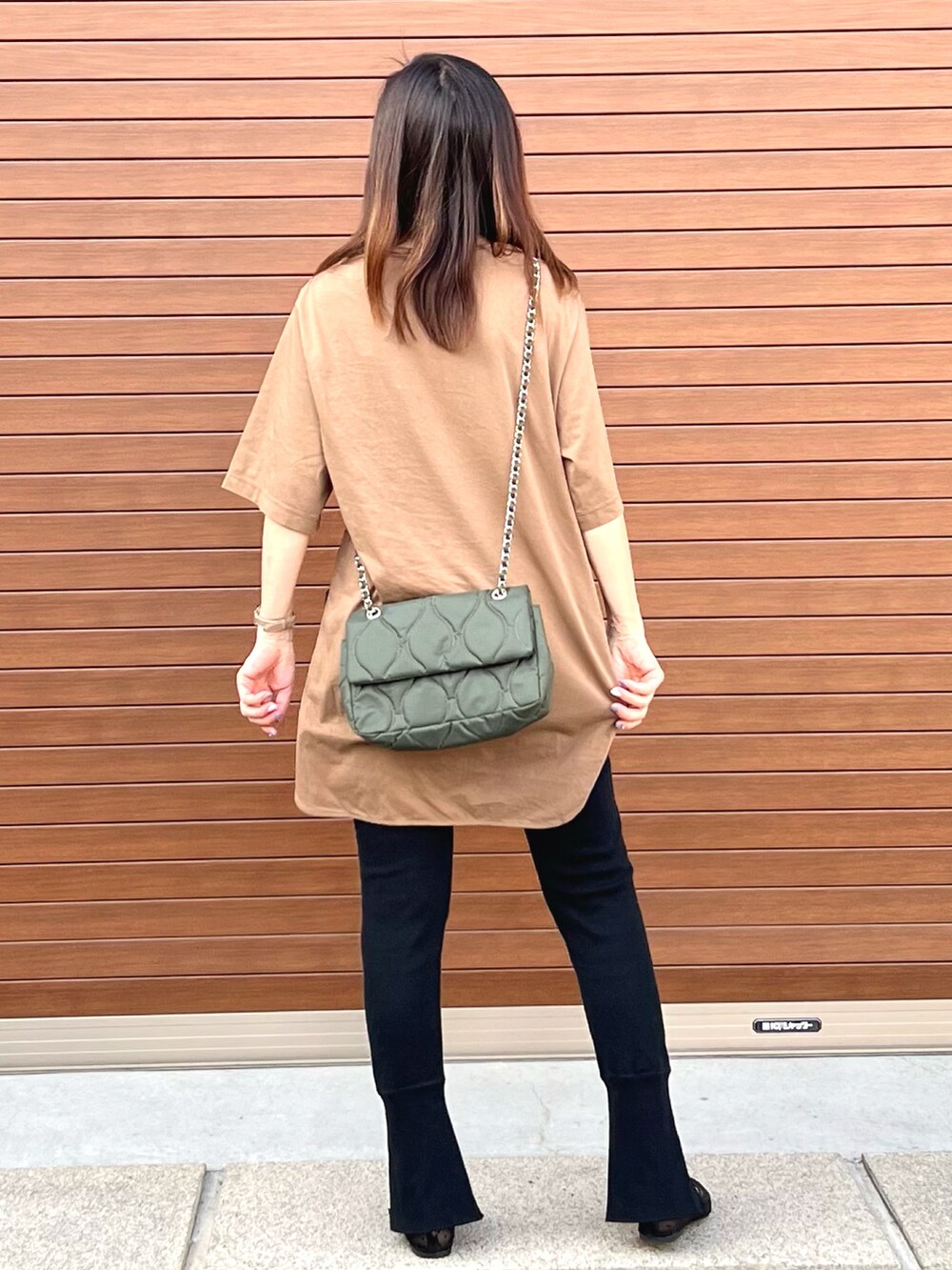 ブラック系のパンツ、ブラウン系のTシャツ/カットソー、グリーン系のショルダーバッグを着用したレディースの夏コーディネートの3枚目の写真