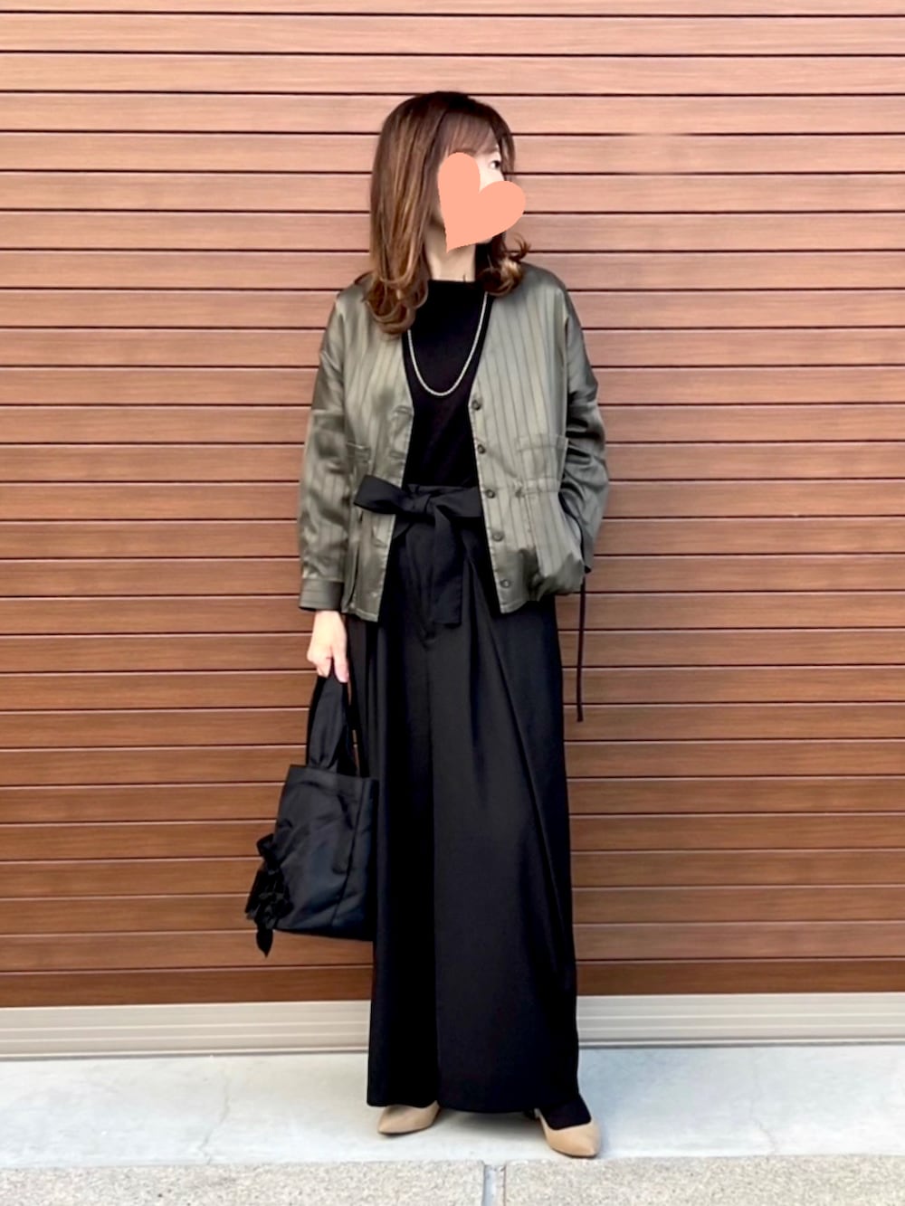 グリーン系のその他アウター、ブラック系のニット/セーター、ブラック系のスラックスを着用したレディースの冬コーディネートの2枚目の写真