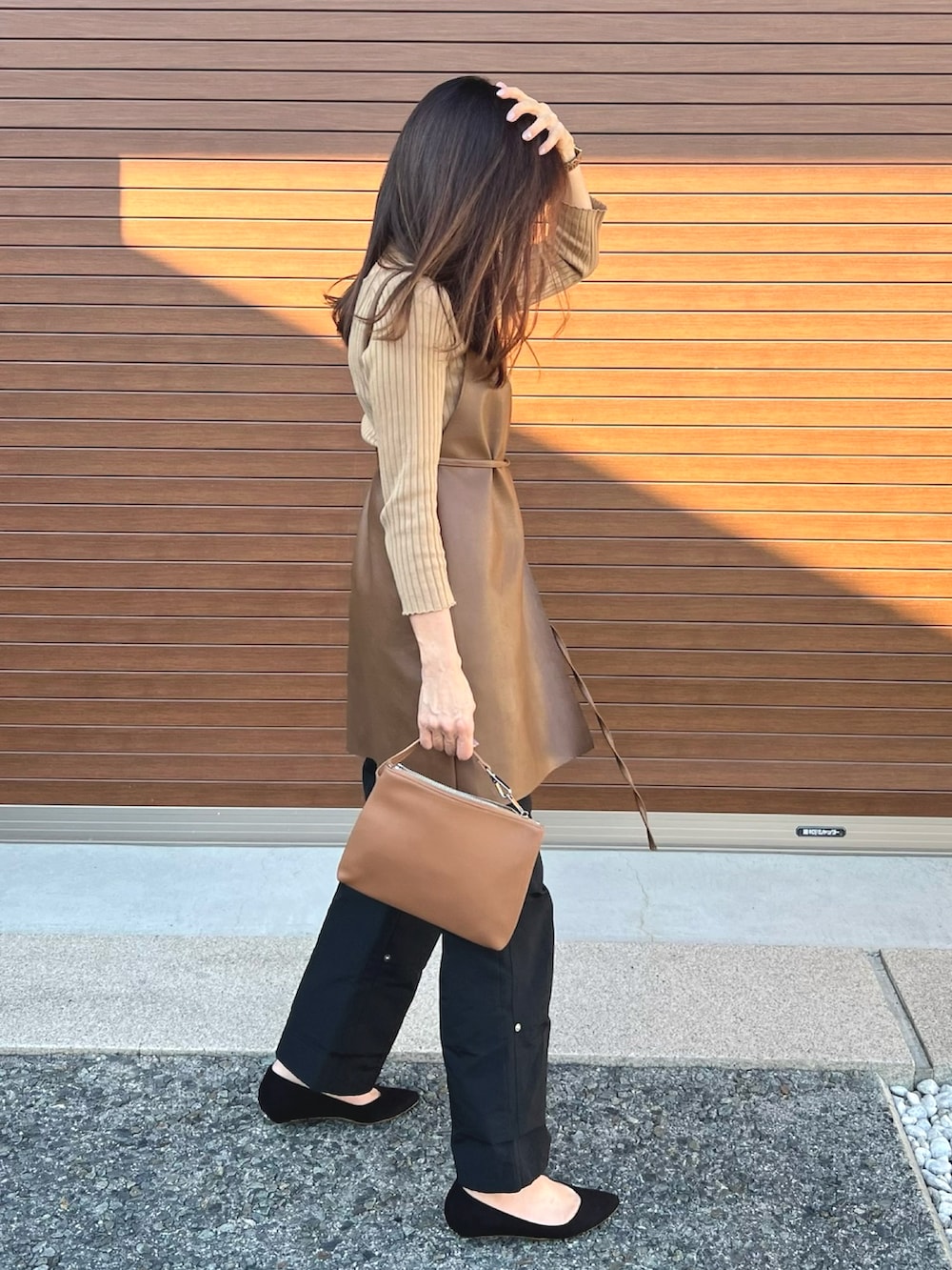 ブラウン系のベスト、ブラック系のその他パンツ、ベージュ系のニット/セーターを着用したレディースの秋コーディネートの2枚目の写真